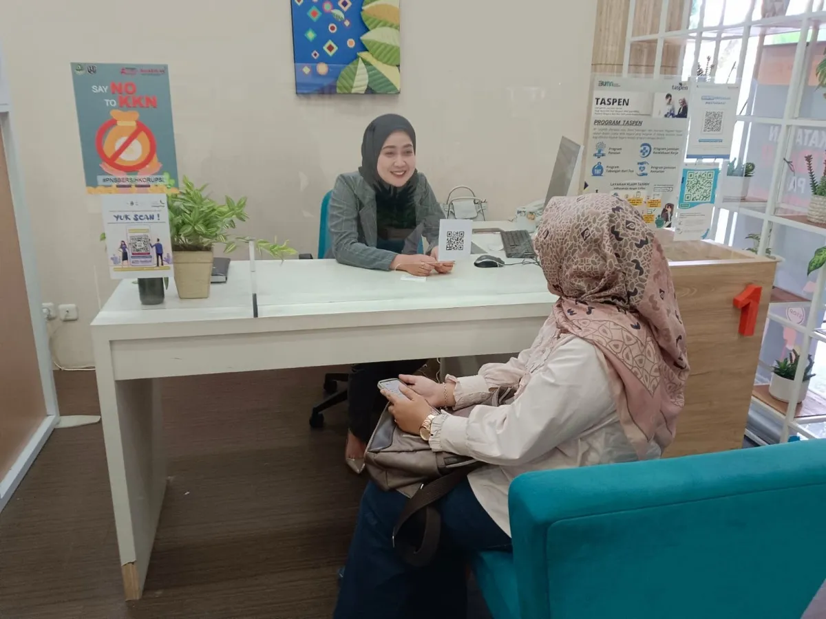 Petugas front office melayani tamu di meja layanan