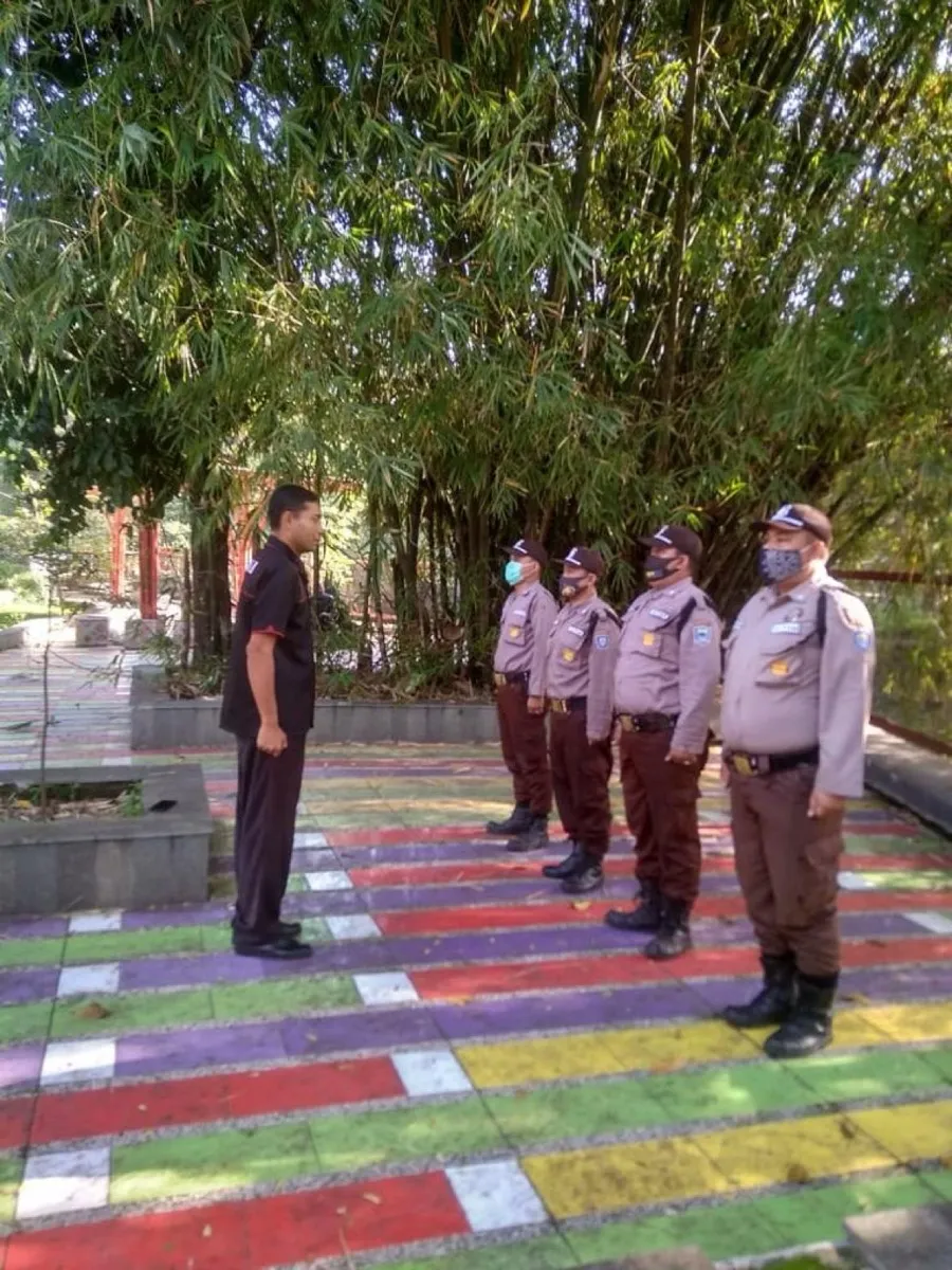 Barisan anggota keamanan di taman rumah sakit